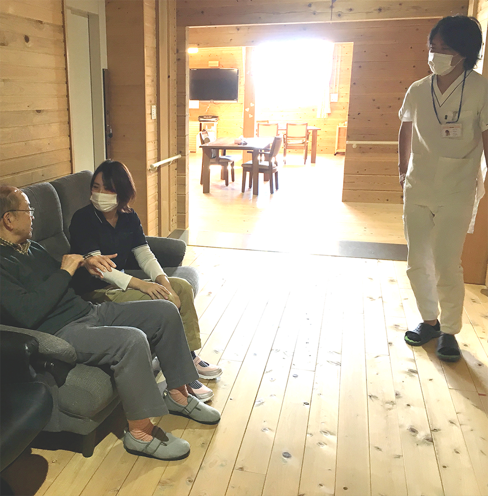木造温暖感のある共用部でスタッフと入居者が過ごす様子